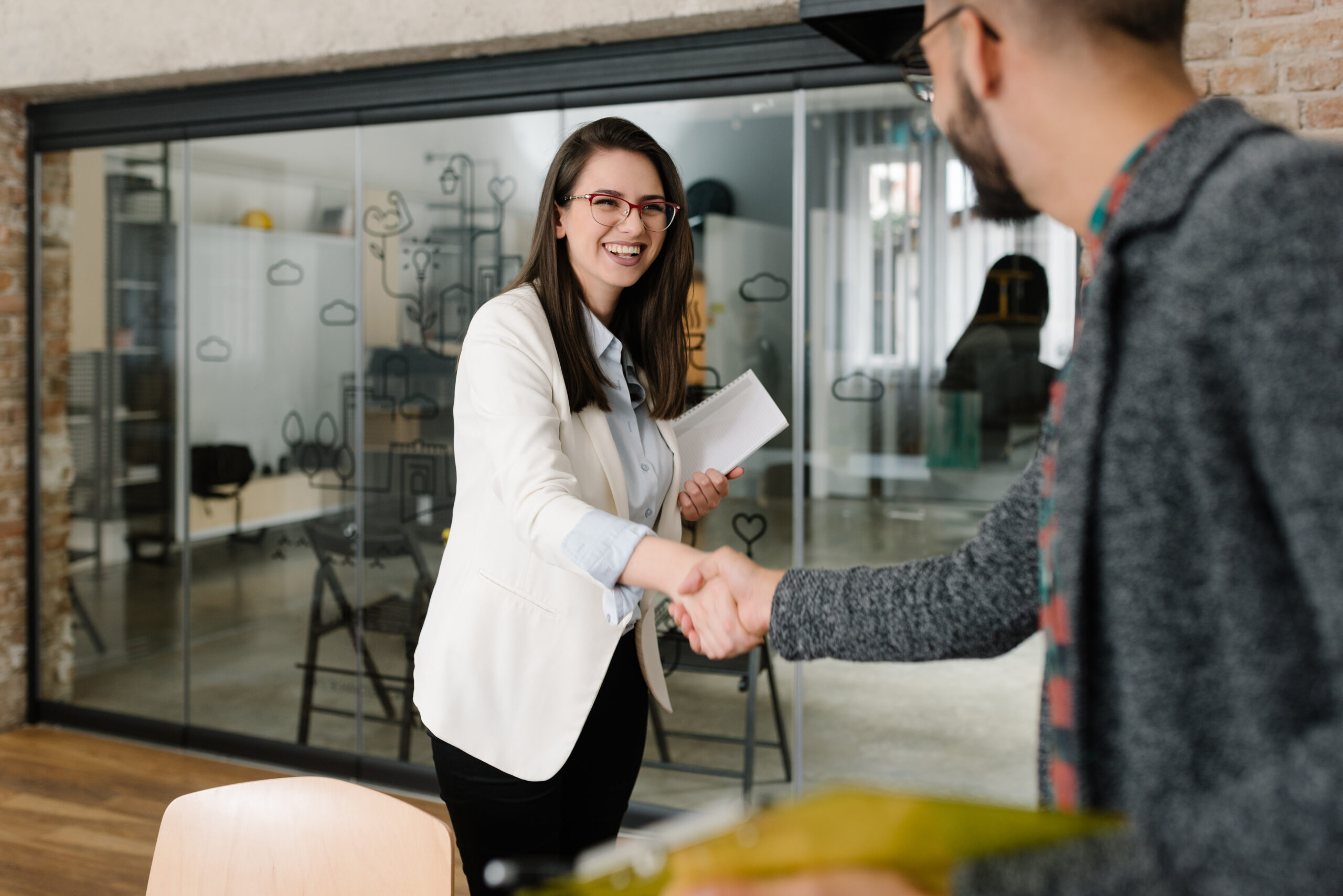 A sales professional meeting a client with a confident handshake.